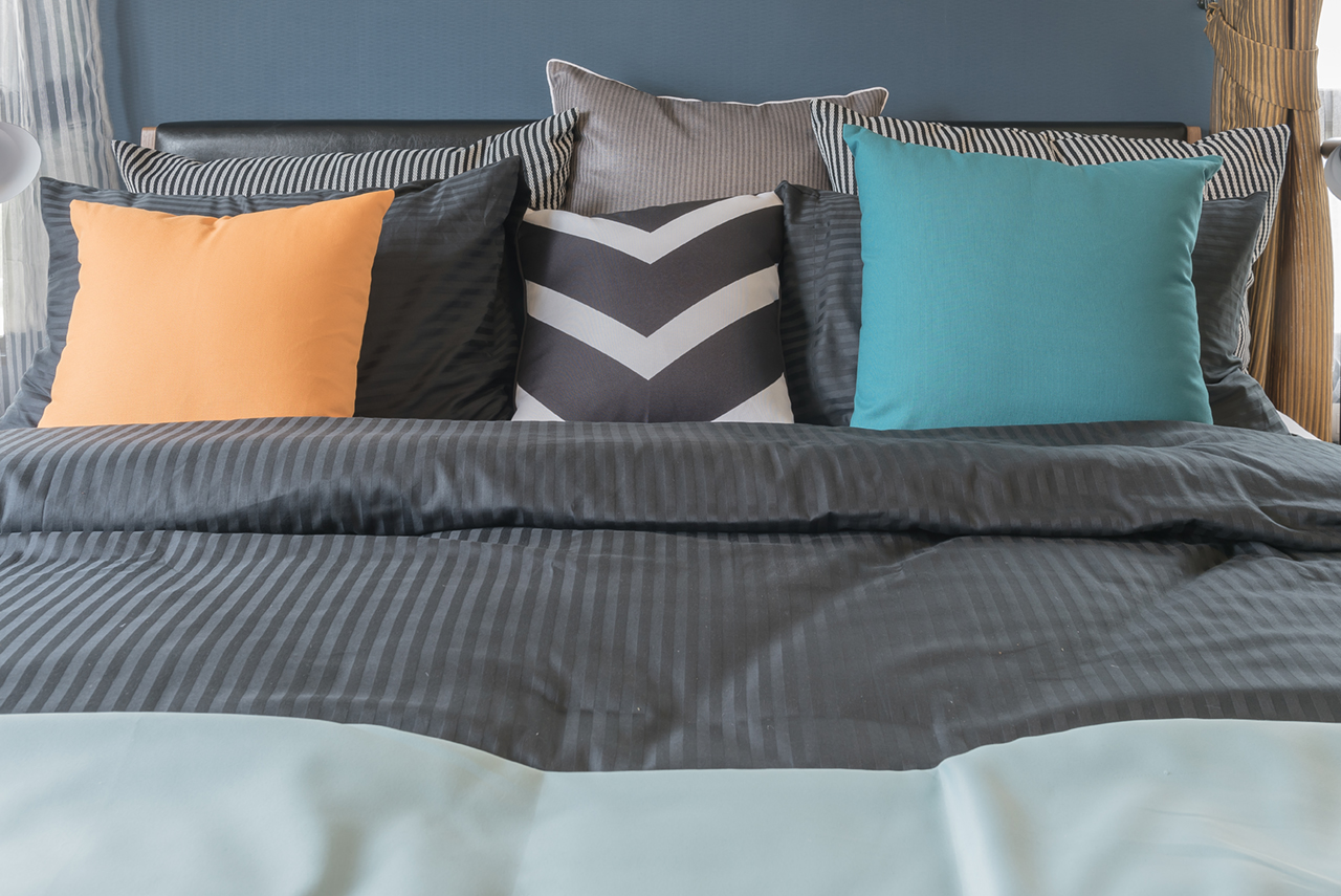 colorful-pillows-on-dark-color--bed-in-modern-bedroom