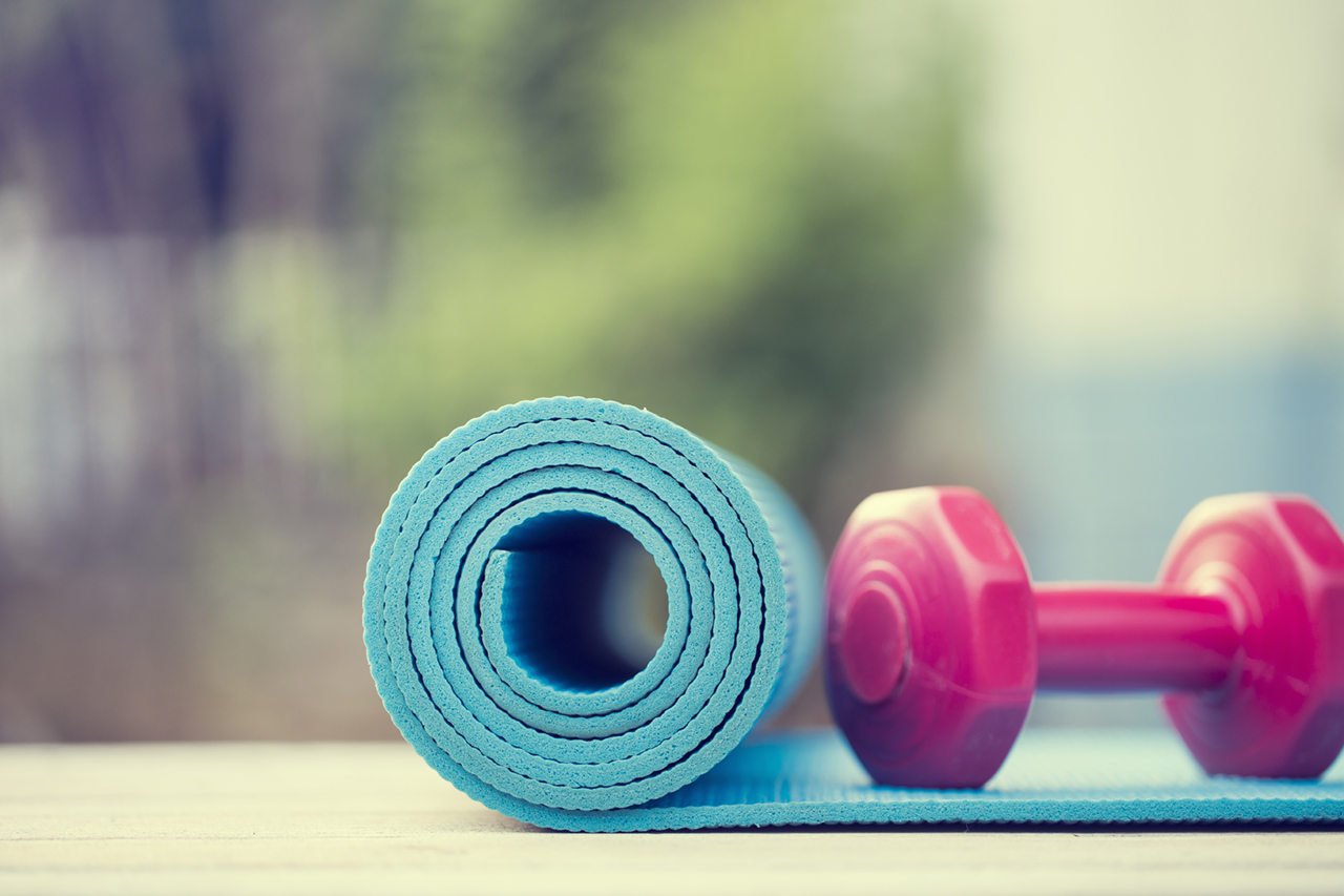 dumbbell-and-yoga-mat-on-wood-table